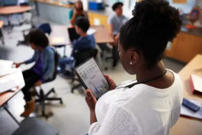 teacher using tablet overseeing students